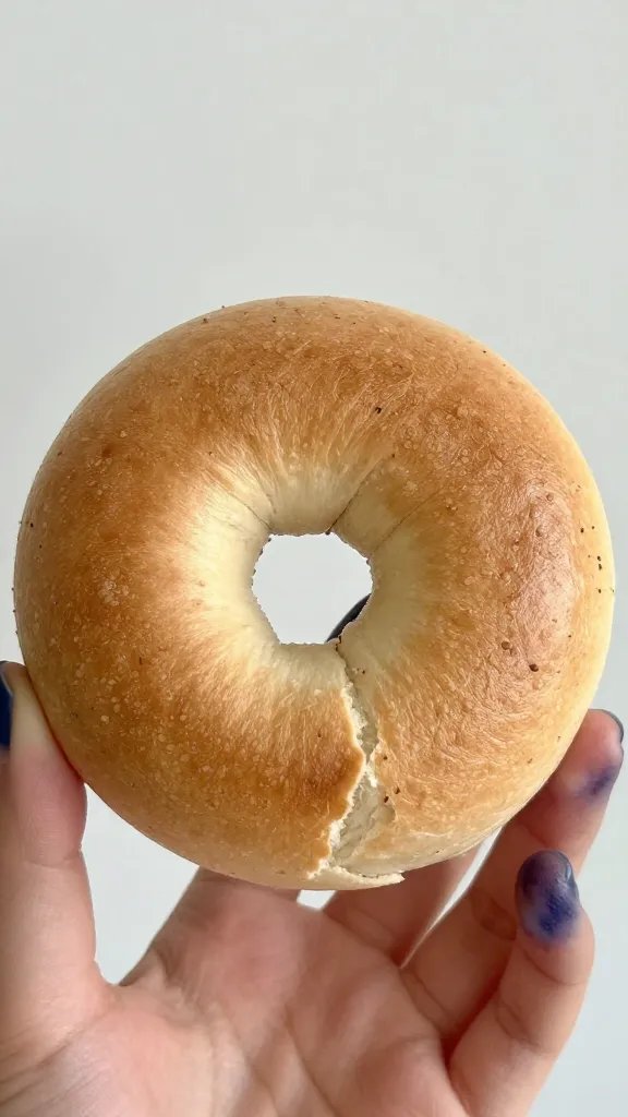 blueberry-stained fingertips holding warm bagel bite