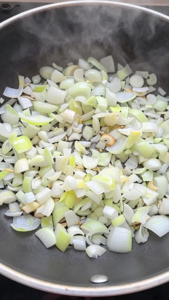 diced onions softening in skillet, steam visible
